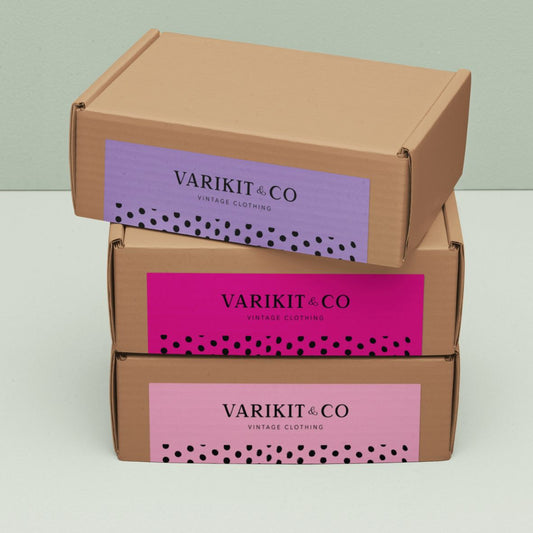 Stacked cardboard boxes sealed with custom logo thermal labels, offering a budget-friendly alternative to custom packing tape.